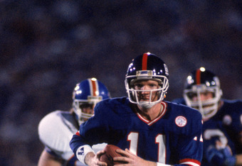 PASADENA, CA - JANUARY 25:  Quarterback Phil Simms #11 of the New York Giants runs with the ball against the Denver Broncos during Super Bowl XXI at the Rose Bowl on January 25, 1987 in Pasadena, California. The Giants defeated the Broncos 39-20. (Photo by George Rose/Getty Images)