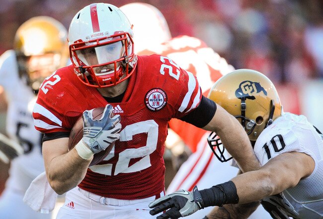 LINCOLN, NE - NOVEMBER 26: Rex Burkhead #22 of the Nebraska Cornhuskers runs past Michael Sipili #10 of the Colorado Buffaloes during the first half of their game at Memorial Stadium on November 26, 2010 in Lincoln, Nebraska.  (Photo by Eric Francis/Getty Images)