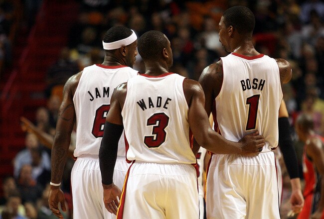 MIAMI - NOVEMBER 06: Dwyane Wade #3, LeBron James #6 and Chris Bosh #1 of the Miami Heat chat during a game against the New Jersey Nets  at American Airlines Arena on November 6, 2010 in Miami, Florida. NOTE TO USER: User expressly acknowledges and agrees that, by downloading and or using this photograph, User is consenting to the terms and conditions of the Getty Images License Agreement.  (Photo by Marc Serota/Getty Images)