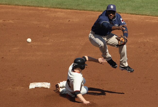 SAN FRANCISCO - OCTOBER 02:  Miguel Tejada #10 of the San Diego Padres turns a double play as Mike Fontenot #14 of the San Francisco Giants slides in to second base at AT&T Park on October 2, 2010 in San Francisco, California.  (Photo by Ezra Shaw/Getty Images)