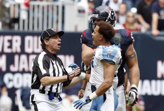 HOUSTON - NOVEMBER 28:  Cornerback Cortland Finnegan #31 of the Tennessee Titans is held back by an official after getting into a fight with Andre Johnson of the Houston Texans at Reliant Stadium on November 28, 2010 in Houston, Texas.  (Photo by Bob Levey/Getty Images)