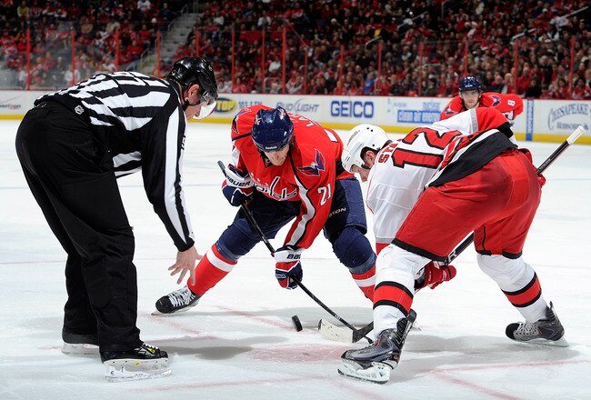 WASHINGTON - NOVEMBER 28:  Brooks Laich #21 of the Washington Capitals takes a face off against Eric Staal #12 of the Carolina Hurricanes at the Verizon Center on November 28, 2010 in Washington, DC.  (Photo by Greg Fiume/Getty Images)
