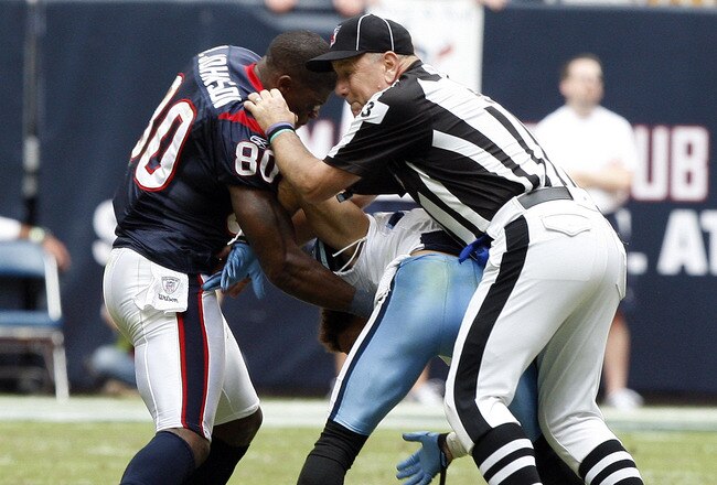 HOUSTON - NOVEMBER 28:  Wide receiver Andre Johnson #80 of the Houston Texans is separated by umpire Garth DeFerlice #53 from cornerback Cortland Finnegan #31 of the Tennessee Titans after the two exchanged punches in the fourth quarter at Reliant Stadium on November 28, 2010 in Houston, Texas.  (Photo by Bob Levey/Getty Images)