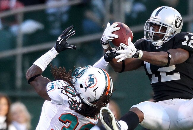 OAKLAND, CA - NOVEMBER 28:  Jacoby Ford #12 of the Oakland Raiders catches the ball while defended by Chris Clemons #30 of the Miami Dolphins at Oakland-Alameda County Coliseum on November 28, 2010 in Oakland, California.  (Photo by Ezra Shaw/Getty Images)