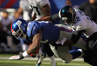 EAST RUTHERFORD, NJ - NOVEMBER 28:  Brandon Jacobs #27 of the New York Giants is tackled by Don Carey #22 of the Jacksonville Jaguars during their game on November 28, 2010 at The New Meadowlands Stadium in East Rutherford, New Jersey.  (Photo by Al Bello/Getty Images)