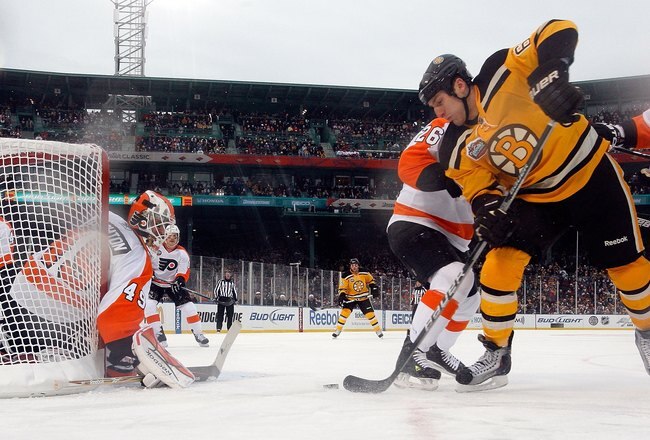 BOSTON, NY - JANUARY 01:  Byron Bitz #61 of the Boston Bruins takes a shot against Michael Leighton #49 of the Philadelphia Flyers during the 2010 Bridgestone Winter Classic at Fenway Park on January 1, 2010  in Boston, Massachusetts.  (Photo by Jim McIsaac/Getty Images)
