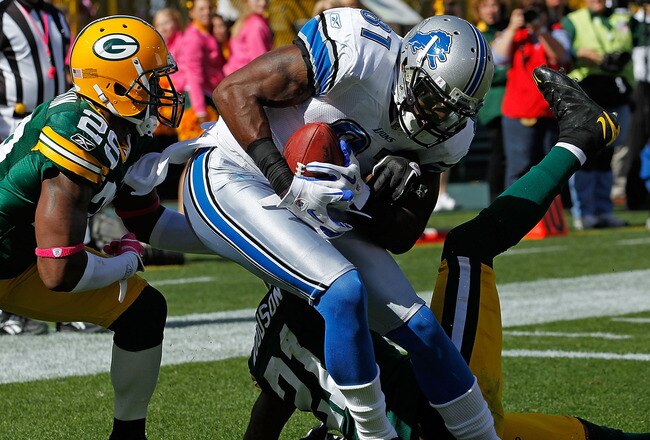 GREEN BAY, WI - OCTOBER 03: Calvin Johnson #81 of the Detroit Lions drops to the end zone after catching a touchdown pass between Derrick Martin #29 and Charles Woodson #21 of the Green Bay Packers at Lambeau Field on October 3, 2010 in Green Bay, Wisconsin. The Packers defeated the Lions 28-26. (Photo by Jonathan Daniel/Getty Images)