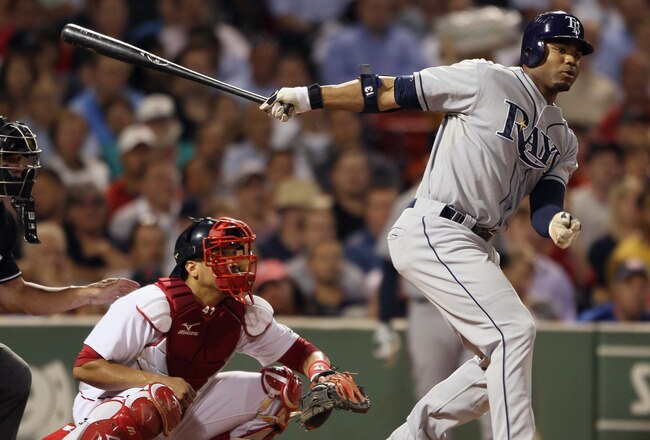 BOSTON - SEPTEMBER 07:  Carl Crawford #13 of the Tampa Bay Rays hits a 2 RBI double in the fourth inning as Victor Martinez #41 of the Boston Red Sox catches on September 7, 2010 at Fenway Park in Boston, Massachusetts.  (Photo by Elsa/Getty Images)