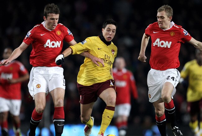 MANCHESTER, ENGLAND - DECEMBER 13:  Samir Nasri of Arsenal competes with Darren Fletcher (R) and Michael Carrick of Manchester United during the Barclays Premier League match between Manchester United and Arsenal at Old Trafford on December 13, 2010 in Manchester, England.  (Photo by Alex Livesey/Getty Images)