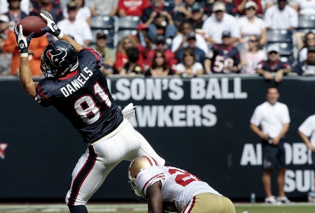 HOUSTON - OCTOBER 25:  Tight-end Owen Daniels #81 of the Houston Texans completes a pass in front of safety Mark Roman #26 of the San Francisco 49ers at Reliant Stadium on October 25, 2009 in Houston, Texas.  (Photo by Bob Levey/Getty Images)