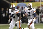 ATLANTA - DECEMBER 4:  Quarterback Cam Newton #2 of the Auburn Tigers (right) runs with the ball while offensive lineman Mike Berry runs with him during the 2010 SEC Championship against the South Carolina Gamecocks at Georgia Dome on December 4, 2010 in Atlanta, Georgia. The Tigers beat the Gamecocks 56-17.  (Photo by Mike Zarrilli/Getty Images)