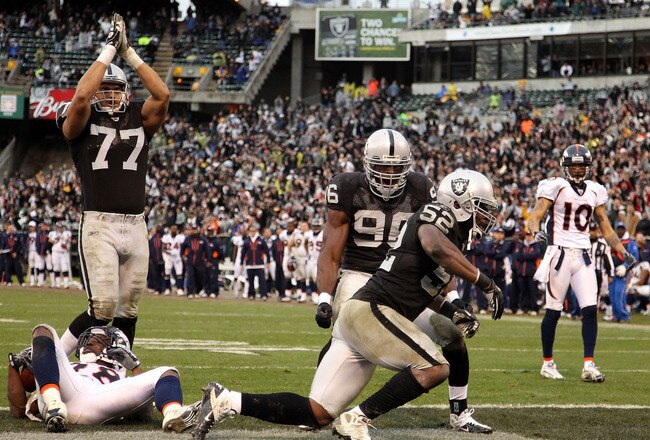 OAKLAND, CA - DECEMBER 19:  Quentin Groves #52 of the Oakland Raiders celebrates with Kamerion Wimbley #96 and Matt Shaughnessy #77 after he stopped Correll Buckhalter #28 of the Denver Broncos for a safety at Oakland-Alameda County Coliseum on December 19, 2010 in Oakland, California.  (Photo by Ezra Shaw/Getty Images)