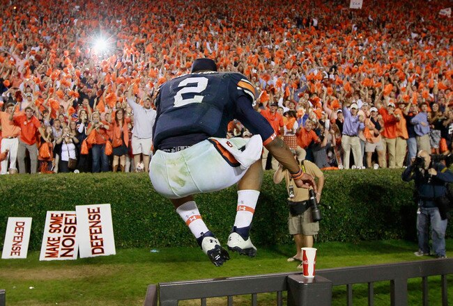 AUBURN, AL - NOVEMBER 13:  Quarterback Cameron Newton #2 of the Auburn Tigers leaps over a fence as he clebrates with fans after their 49-31 win over the Georgia Bulldogs at Jordan-Hare Stadium on November 13, 2010 in Auburn, Alabama.  (Photo by Kevin C. Cox/Getty Images)