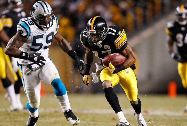 PITTSBURGH - DECEMBER 23:  Mike Wallace #17 of the Pittsburgh Steelers runs by Nic Harris #59 of the Carolina Panthers before scoring a touchdown during the game on December 23, 2010 at Heinz Field in Pittsburgh, Pennsylvania.  (Photo by Jared Wickerham/Getty Images)