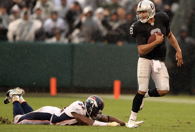 OAKLAND, CA - DECEMBER 19:  Jason Campbell #8 of the Oakland Raiders escapes a diving Jason Hunter #52 of the Denver Broncos at Oakland-Alameda County Coliseum on December 19, 2010 in Oakland, California.  (Photo by Ezra Shaw/Getty Images)