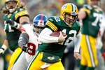 GREEN BAY, WI - DECEMBER 26:  Aaron Rodgers #12 of the Green Bay Packers is chased out of the pocket against the New York Giants at Lambeau Field on December 26, 2010 in Green Bay, Wisconsin.  (Photo by Matthew Stockman/Getty Images)
