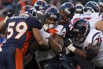 DENVER - DECEMBER 26:  Running back Arian Foster #23 of the Houston Texas is stopped by Kevin Vickerson #99 and Wesley Woodyard #59 of the Denver Broncos at INVESCO Field at Mile High on December 26, 2010 in Denver, Colorado. The Broncos defeated the Texans 24-23.  (Photo by Doug Pensinger/Getty Images)