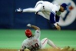 17 Oct 1993: Roberto Alomar of the Toronto Blue Jays flies over Darren Daulton of the Philadelphia Phillies during game 2 of the 1993 World Series.
