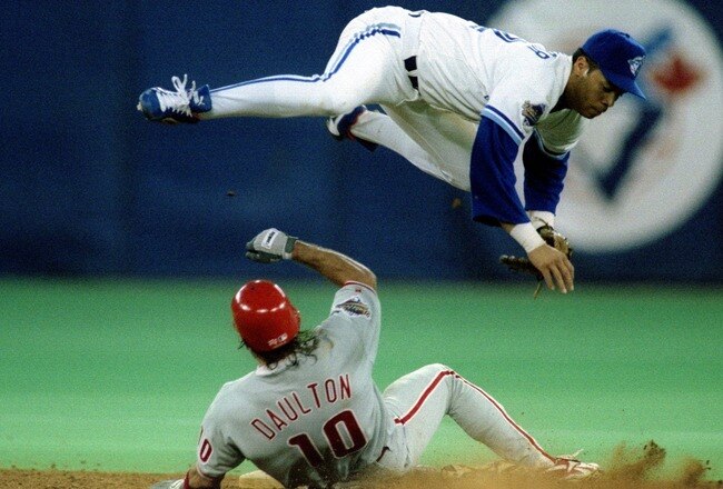 17 Oct 1993: Roberto Alomar of the Toronto Blue Jays flies over Darren Daulton of the Philadelphia Phillies during game 2 of the 1993 World Series.