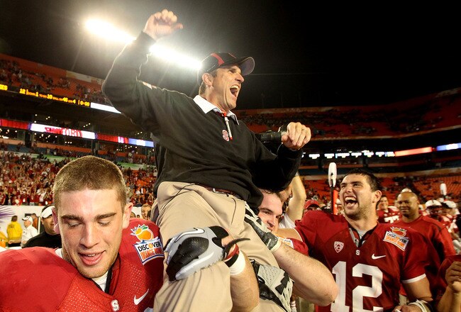 MIAMI, FL - JANUARY 03: Head coach Jim Harbaugh of the Stanford Cardinal celebrates as he is lifted up by his players including Orange Bowl MVP Andrew Luck #12 (R) after Stanford won 40-12 against the Virginia Tech Hokies during the 2011 Discover Orange Bowl at Sun Life Stadium on January 3, 2011 in Miami, Florida. (Photo by Streeter Lecka/Getty Images)
