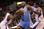 LOS ANGELES, CA - JANUARY 05:  Carmelo Anthony #15 of the Denver Nuggets fights to drive through Baron Davis #5 and Ryan Gomes #15 of the Los Angeles Clippers at Staples Center on January 5, 2011  in Los Angeles, California.  NOTE TO USER: User expressly acknowledges and agrees that, by downloading and or using this photograph, User is consenting to the terms and conditions of the Getty Images License Agreement.  (Photo by Stephen Dunn/Getty Images)