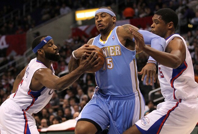 LOS ANGELES, CA - JANUARY 05:  Carmelo Anthony #15 of the Denver Nuggets fights to drive through Baron Davis #5 and Ryan Gomes #15 of the Los Angeles Clippers at Staples Center on January 5, 2011  in Los Angeles, California.  NOTE TO USER: User expressly acknowledges and agrees that, by downloading and or using this photograph, User is consenting to the terms and conditions of the Getty Images License Agreement.  (Photo by Stephen Dunn/Getty Images)