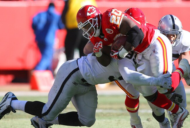 KANSAS CITY, MO - JANUARY 02:  Running back Thomas Jones #25 of the Kansas City Chiefs is tackled by defensive end Lamarr Houston #99 of the Oakland Raiders in a game at Arrowhead Stadium on January 2, 2011 in Kansas City, Missouri.  (Photo by Tim Umphrey/Getty Images)
