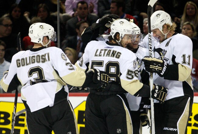 MONTREAL, CANADA - JANUARY 12:  Chris Kunitz #14 of the Pittsburgh Penguins celebrates his third period goal with team mates (L-R) Alex Goligoski #3, Kris Letang #58 and Jordan Staal #11 during the NHL game against the Montreal Canadiens at the Bell Centre on January 12, 2011 in Montreal, Quebec, Canada.  The Penguins defeated the Canadiens 5-2.  (Photo by Richard Wolowicz/Getty Images)