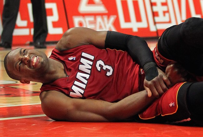 CHICAGO, IL - JANUARY 15:  Dwayne Wade #3 of the Miami Heat grimaces as he lies on the floor after being fouled by the Chicago Bulls at the United Center on January 15, 2011 in Chicago, Illinois. NOTE TO USER: User expressly acknowledges and agrees that, by downloading and or using this photograph, User is consenting to the terms and conditions of the Getty Images License Agreement.  (Photo by Doug Pensinger/Getty Images)