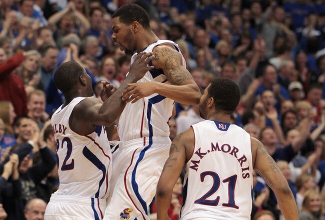 LAWRENCE, KS - DECEMBER 18:  Josh Selby #32 of the Kansas Jayhawks celebrates with Marcus Morris #22 and Markieff Morris #21 after sinking a three-pointer during the final seconds of the game against the USC Trojans on December 18, 2010 at Allen Fieldhouse in Lawrence, Kansas.  The Jayhawks defeated the Trojans with a final score of 70-68.  (Photo by Jamie Squire/Getty Images)