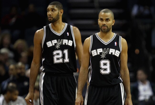 CHARLOTTE, NC - NOVEMBER 08:  Teammates Tony Parker #9 and Tim Duncan #21 of the San Antonio Spurs walk onto the court against the Charlotte Bobcats before their game at Time Warner Cable Arena on November 8, 2010 in Charlotte, North Carolina.  NOTE TO USER: User expressly acknowledges and agrees that, by downloading and/or using this Photograph, User is consenting to the terms and conditions of the Getty Images License Agreement.  (Photo by Streeter Lecka/Getty Images)