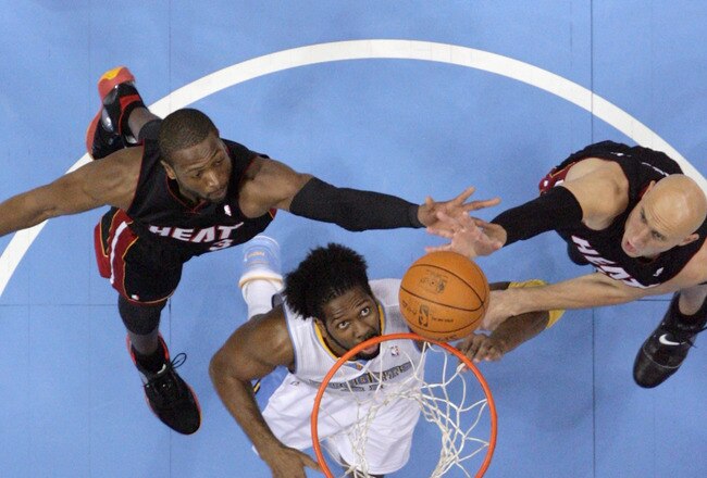 DENVER, CO - JANUARY 13:  Nene #31 of the Denver Nuggets battles for a rebound against Zydrunas Ilgaukas #11 and Dwayne Wade #3 of the Miami Heat at the Pepsi Center on January 13, 2011 in Denver, Colorado. The Nuggets defeated the Heat 130-102. NOTE TO USER: User expressly acknowledges and agrees that, by downloading and or using this photograph, User is consenting to the terms and conditions of the Getty Images License Agreement.  (Photo by Doug Pensinger/Getty Images)