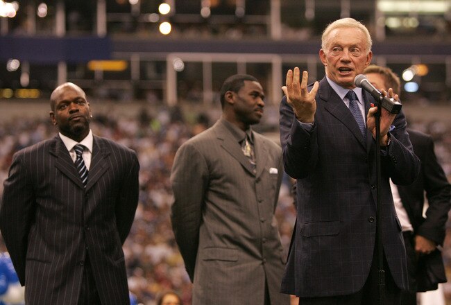 IRVING, TX - SEPTEMBER 19:  Dallas Cowboys team owner Jerry Jones speaks to the crowd as (back L-R) former Cowboys Emmitt Smith, Michael Irvin and Troy Aikman wait to be inducted into the Cowboys ring of honor at half-time of the game between the Washington Redskins and the Dallas Cowboys on September 19, 2005 at Texas Stadium in Irving, Texas. Former Cowboys teammates Troy Aikman, Emmitt Smith and Michael Irvin were all inducted during the half-time ceremony. The Redskins won 14-13. (Photo by Ronald Martinez/Getty Images)