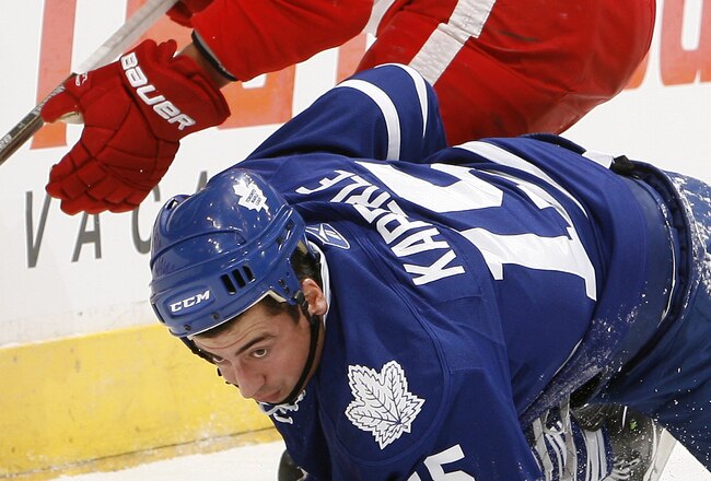 TORONTO - OCTOBER 2: Tomas Kaberle #15 of the Toronto Maple Leafs gets knocked down by Justin Abdelkader #8 of the Detroit Red Wings during a preseason NHL game at the Air Canada Centre October 2, 2010 in Toronto, Ontario, Canada. (Photo by Abelimages/Getty Images)