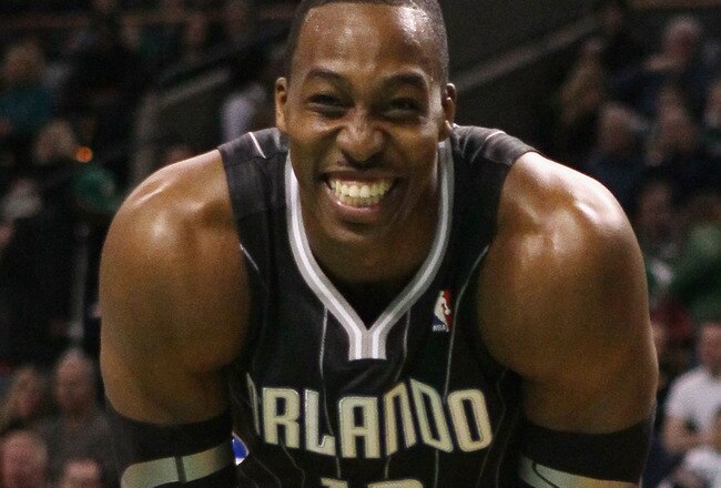 BOSTON, MA - JANUARY 17:  Dwight Howard #12 of the Orlando Magic smiles on the baseline as he waits for Shaquille O'Neal of the Boston Celtics to shoot a free throw on January 17, 2011 at the TD Garden in Boston, Massachusetts.  NOTE TO USER: User expressly acknowledges and agrees that, by downloading and/or using this Photograph, User is consenting to the terms and conditions of the Getty Images License Agreement.  (Photo by Elsa/Getty Images)