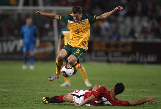 CAIRO, EGYPT - NOVEMBER 17: Jason Culina of Australia leaps above the challenge of Ahmed Samir Farag of Egypt during the Egypt v Australia International Friendly match at the Cairo International Stadium on November 17, 2010 in Cairo, Egypt.  (Photo by Michael Steele/Getty Images)