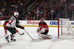 NEWARK, NJ - JANUARY 04: Cal Clutterbuck #22 of the Minnesota Wild scores a first period goal against Johan Hedberg #1 of the New Jersey Devils at the Prudential Center on January 4, 2011 in Newark, New Jersey.  (Photo by Bruce Bennett/Getty Images)