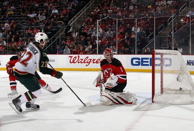 NEWARK, NJ - JANUARY 04: Cal Clutterbuck #22 of the Minnesota Wild scores a first period goal against Johan Hedberg #1 of the New Jersey Devils at the Prudential Center on January 4, 2011 in Newark, New Jersey.  (Photo by Bruce Bennett/Getty Images)