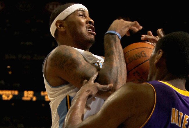 DENVER, CO - JANUARY 21:  Carmelo Anthony #15 of the Denver Nuggets is fouled by Ron Artest #15 of the Los Angeles Lakers at the Pepsi Center on January 21, 2011 in Denver, Colorado. The Lakers defeated the Nuggets 107-97. NOTE TO USER: User expressly acknowledges and agrees that, by downloading and or using this photograph, User is consenting to the terms and conditions of the Getty Images License Agreement.  (Photo by Doug Pensinger/Getty Images)