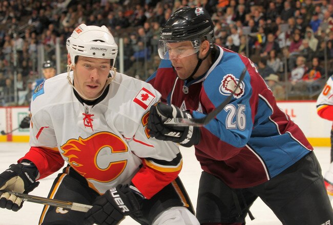 DENVER - NOVEMBER 09:  David Moss #25 of the Calgary Flames and Paul Stastny #26 of the Colorado Avalanche battle for position at the Pepsi Center on November 9, 2010 in Denver, Colorado. The Flames defeated the Avalanche 4-2.  (Photo by Doug Pensinger/Getty Images)