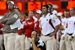 LINCOLN, NEBRASKA - SEPTEMBER 25: Nebraska co-defensive coordinator Carl Pelini (kneeling) and head coach Bo Pelini (L) watch their defense against the South Dakota State Jackrabbits during first half action of their game at Memorial Stadium on September 25, 2010 in Lincoln, Nebraska. Nebraska Defeated South Dakota State 17-3. (Photo by Eric Francis/Getty Images)