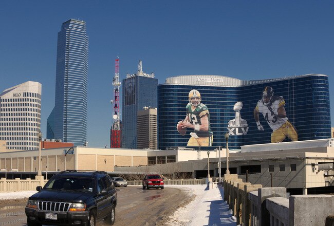 DALLAS, TX - FEBRUARY 5: General view of the downtown skyline with Super Bowl XLV art draped from the Omni Hotel as motorists make their way along on February 5, 2011 in Dallas, Texas. The Green Bay Packers will play the Pittsburgh Steelers in Super Bowl XLV on February 6, 2011 at Cowboys Stadium in Arlington, Texas. (Photo by Joe Robbins/Getty Images)