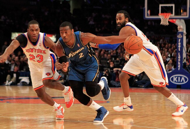 NEW YORK, NY - JANUARY 24: John Wall #2 of the Washington Wizards drives past  Toney Douglas #23 of the New York Knicks at Madison Square Garden on January 24, 2011 in New York City. NOTE TO USER: User expressly acknowledges and agrees that, by downloading and/or using this Photograph, User is consenting to the terms and conditions of the Getty Images License Agreement. The Knicks defeated the Wizards 115-106. (Photo by Chris Trotman/Getty Images)
