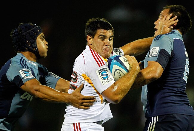 AUCKLAND, NEW ZEALAND - FEBRUARY 11:  Dwayne Sweeney of the Chiefs fends the tackle of Chris Lowrey and Benson Stanley of the Blues during the Super Rugby trial match between the Chiefs and the Blues at Growers Stadium on February 11, 2011 in Auckland, New Zealand.  (Photo by Simon Watts/Getty Images)