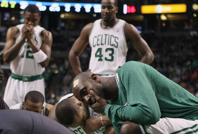 BOSTON, MA - FEBRUARY 06: Kevin Garnett #5,Glen Davis #11,Kendrick Perkins #43 and Von Wafter #12 of the Boston Celtics watch as medical personnel tend to Marquis Daniels of the Celtics after Daniels collided with Gilbert Arenas of the Orlando Magic on February 6, 2011 at the TD Garden in Boston, Massachusetts.  NOTE TO USER: User expressly acknowledges and agrees that, by downloading and/or using this Photograph, User is consenting to the terms and conditions of the Getty Images License Agreement.  (Photo by Elsa/Getty Images)