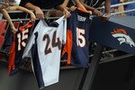DENVER - AUGUST 21:  Bronco fans dangle jerseys of Champ Bailey and Tim Tebow into the tunnel entrance to the field hoping for an autograph prior to the game as the Denver Broncos host the Detroit Lions during preseason NFL action at INVESCO Field at Mile High on August 21, 2010 in Denver, Colorado.  (Photo by Doug Pensinger/Getty Images)