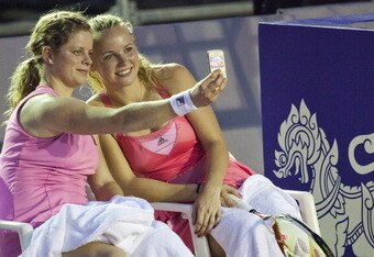 HUA HIN, THAILAND - JANUARY 01:   Kim Clijsters of Belgium take a picture using her mobile phone with Caroline Wozniacki of Denmark during their exhibition match at Centenial Park on January 1, 2011 in Hua Hin, Thailand.  (Photo by Athit Perawongmetha/Getty Images)
