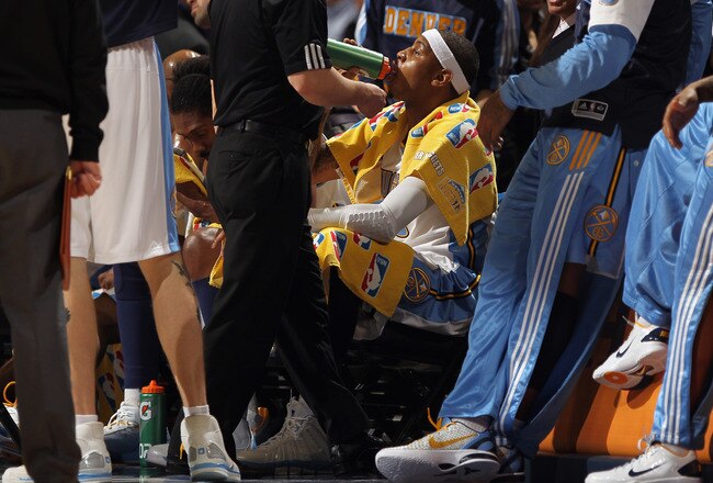 DENVER, CO - FEBRUARY 10:  Carmelo Anthony #15 of the Denver Nuggets takes a drink on the bench during a time out against the Dallas Mavericks during NBA action at the Pepsi Center on February 10, 2011 in Denver, Colorado. The Nuggets defeated the Mavericks 121-120. NOTE TO USER: User expressly acknowledges and agrees that, by downloading and or using this photograph, User is consenting to the terms and conditions of the Getty Images License Agreement.  (Photo by Doug Pensinger/Getty Images)