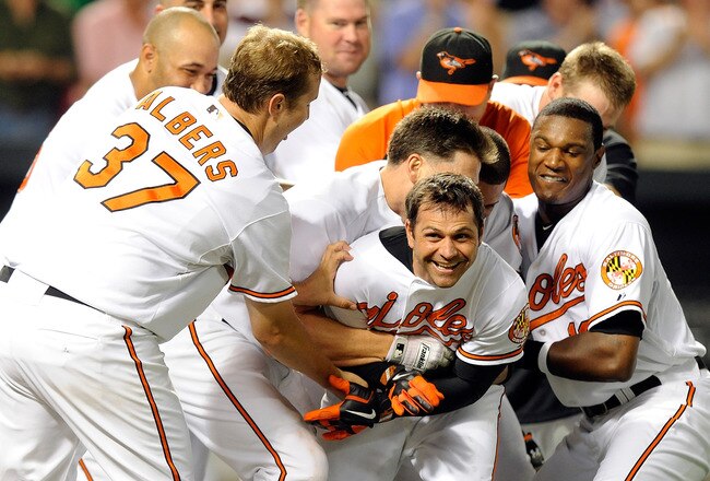 BALTIMORE - AUGUST 09:  Brian Roberts #1 of the Baltimore Orioles is mobbed by teammates after hitting the game winning home run in the tenth inning against the Chicago White Sox at Camden Yards on August 9, 2010 in Baltimore, Maryland. The Orioles won the game 3-2.  (Photo by Greg Fiume/Getty Images)