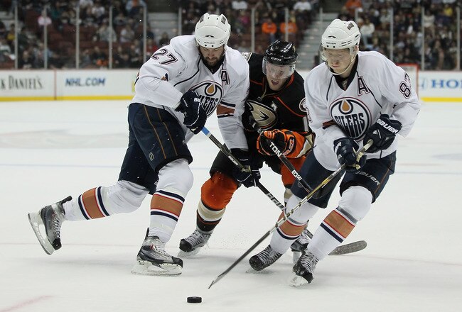 ANAHEIM, CA - JANUARY 16:  (L-R) Dustin Penner #27 of the Edmonton Oilers defends against Saku Koivu #11 of the Anaheim Ducks as Ales Hemsky #83 of the Oilers controls the puck in the first period at the Honda Center on January 16, 2011 in Anaheim, California.  (Photo by Jeff Gross/Getty Images)